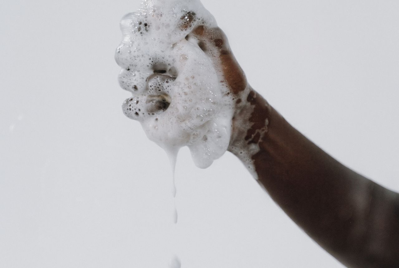 A hand covered in rich soap lather — soft water makes soap and shampoo lather better