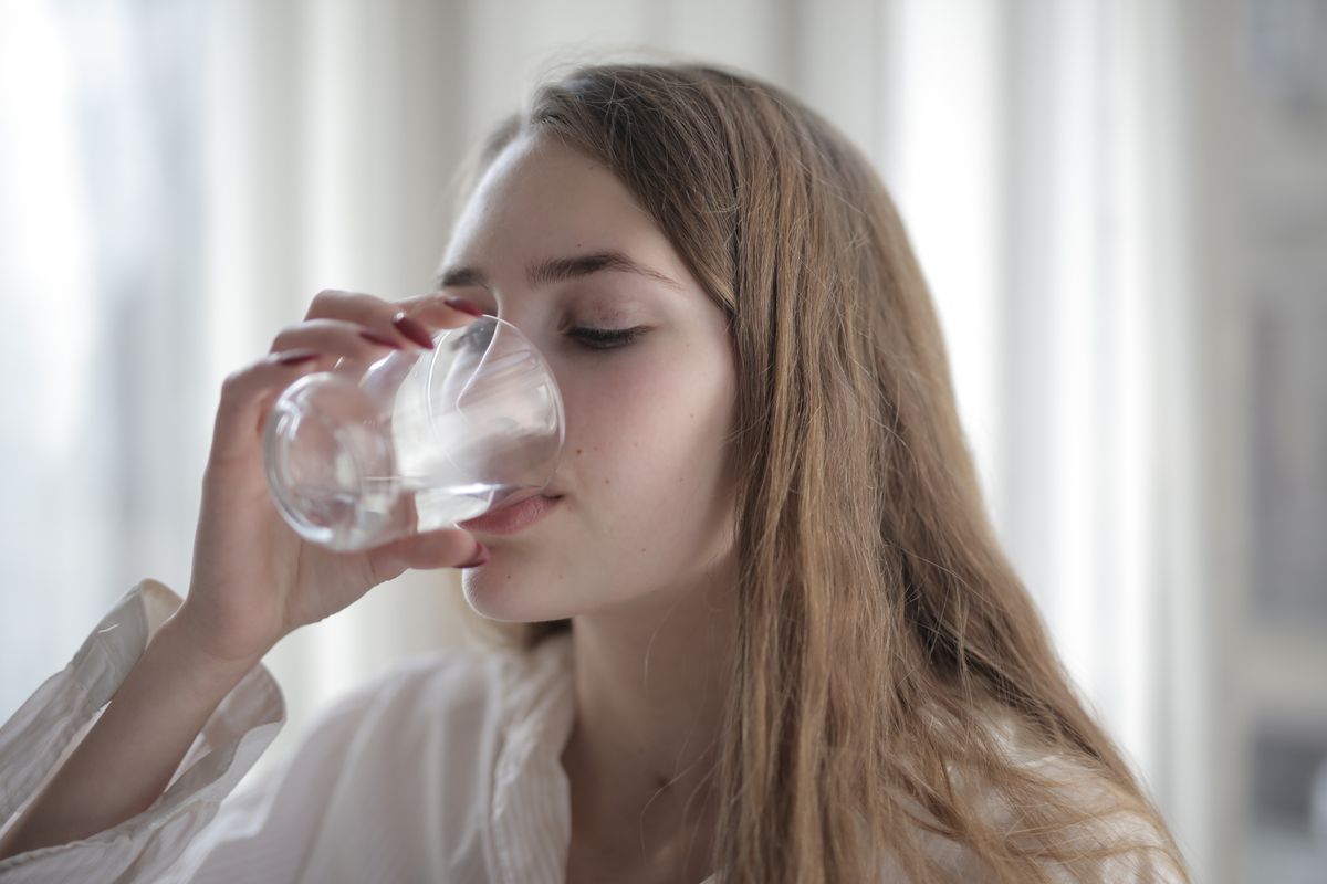 Woman enjoying a glass of soft, mineral-balanced drinking water
